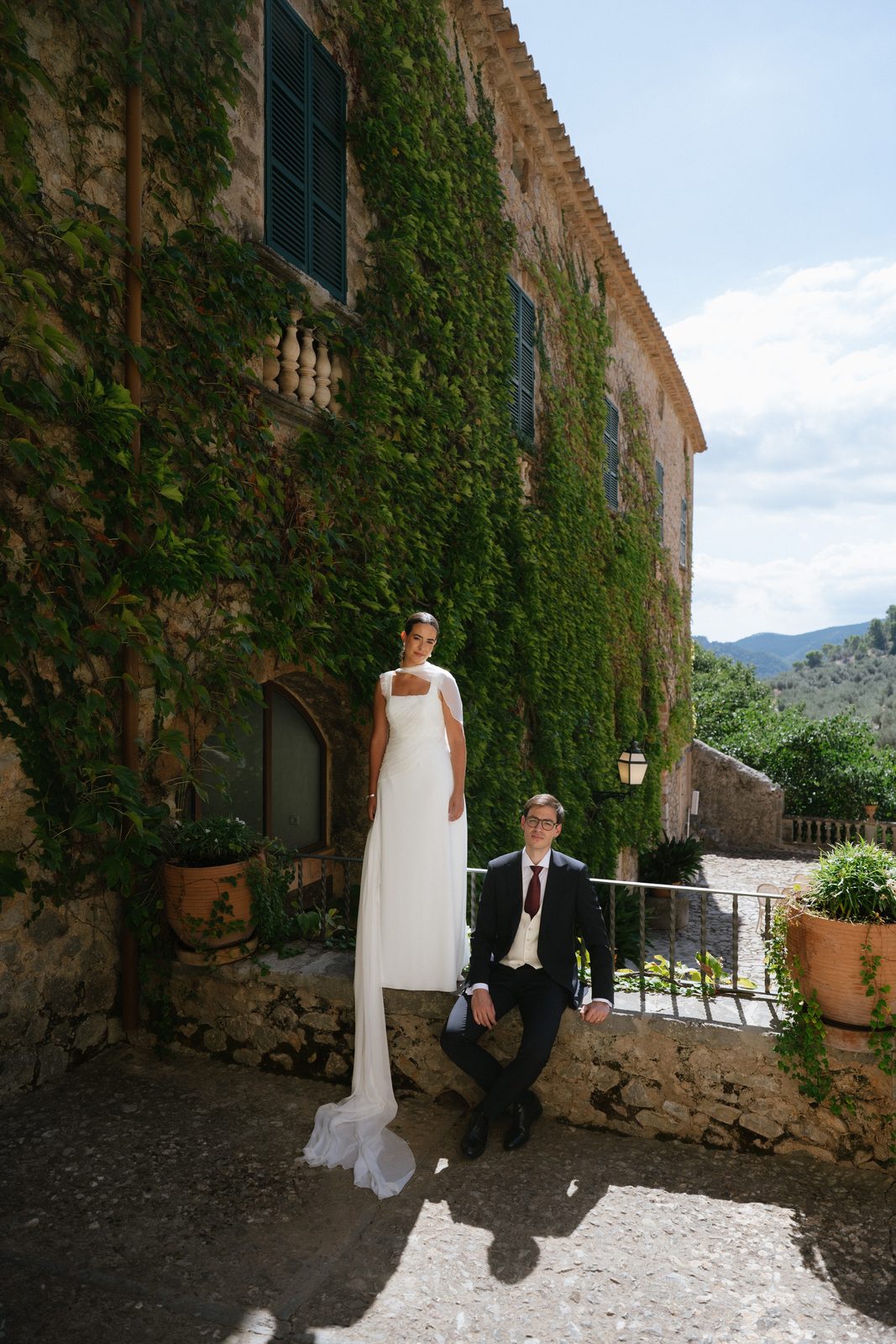 The bride and groom against the ivy-covered facade of Comassema, Bunyola, Mallorca