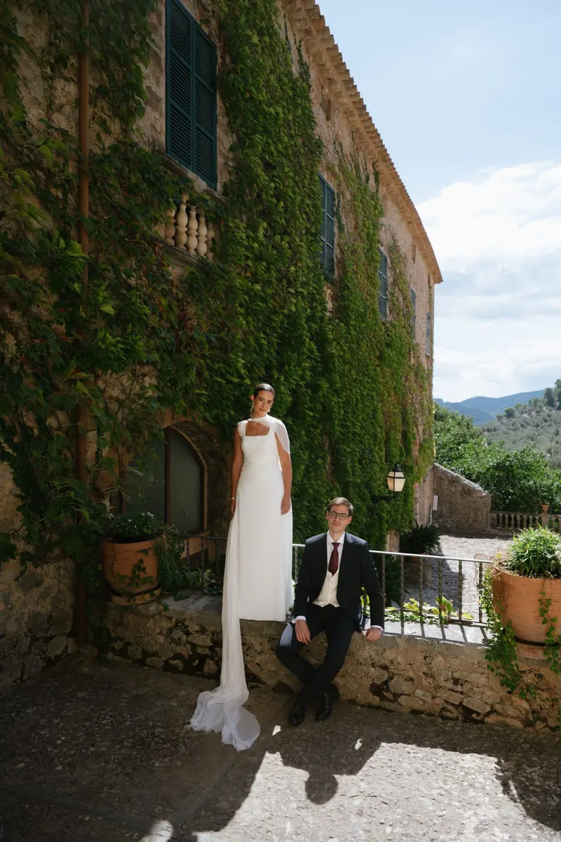 The bride and groom against the ivy-covered facade of Comassema, Bunyola, Mallorca