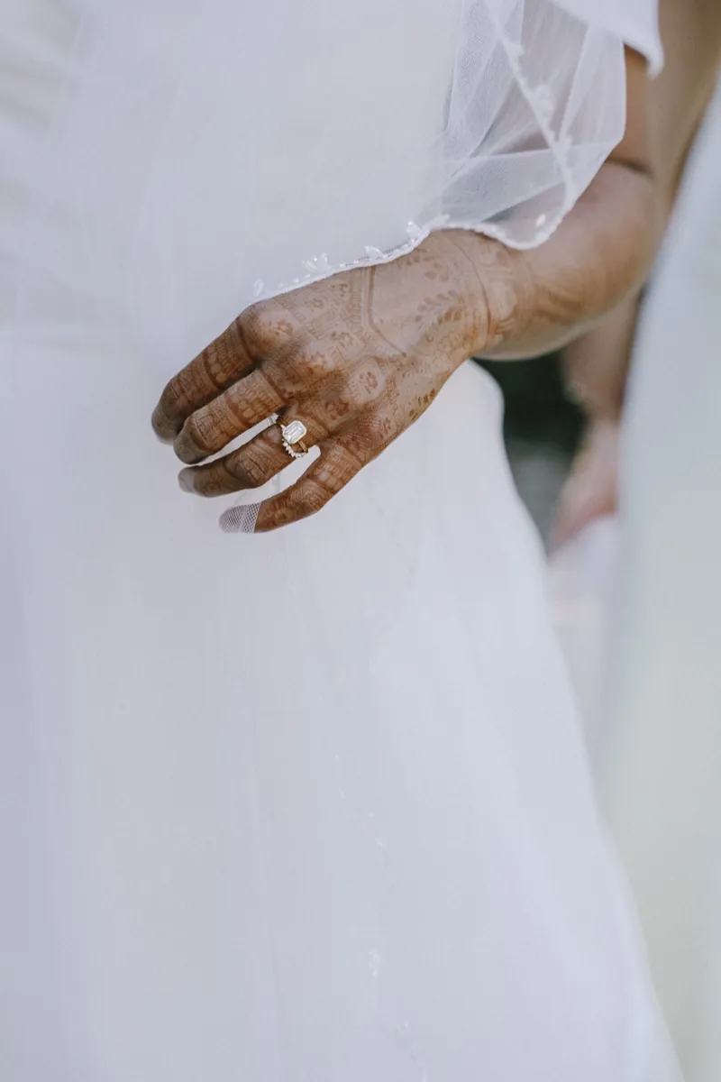 An older guest’s hand resting against the bride’s dress, shot on 35mm film, Biniagual, Mallorca