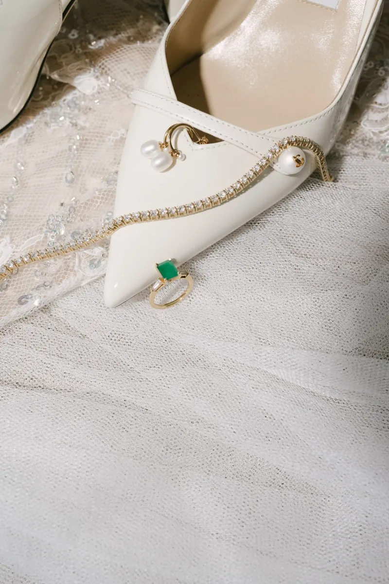 The bride’s shoe, pearls and an emerald ring laid on tulle, Lume & Co, Génova, Mallorca
