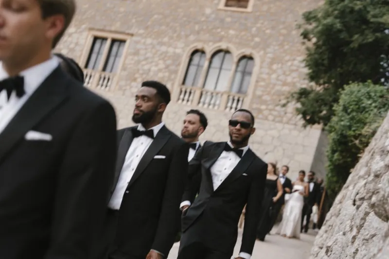 The groom and his groomsmen in black tie outside the stone house, Son Marroig, Deià, Mallorca