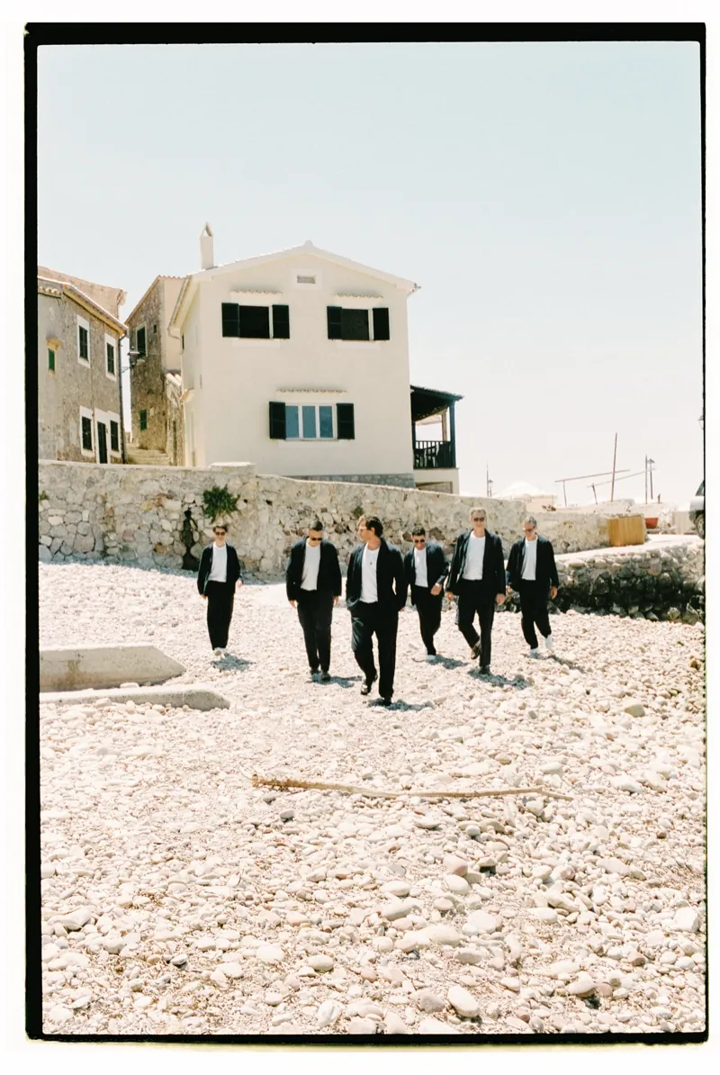 The groom and his friends crossing the yard in black tie, shot on 35mm film, Son Marroig, Deià, Mallorca