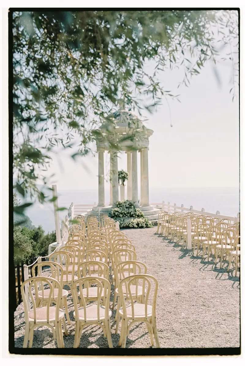 The rotunda seen through olive branches, chairs set for the ceremony, shot on 35mm film, Son Marroig, Deià, Mallorca