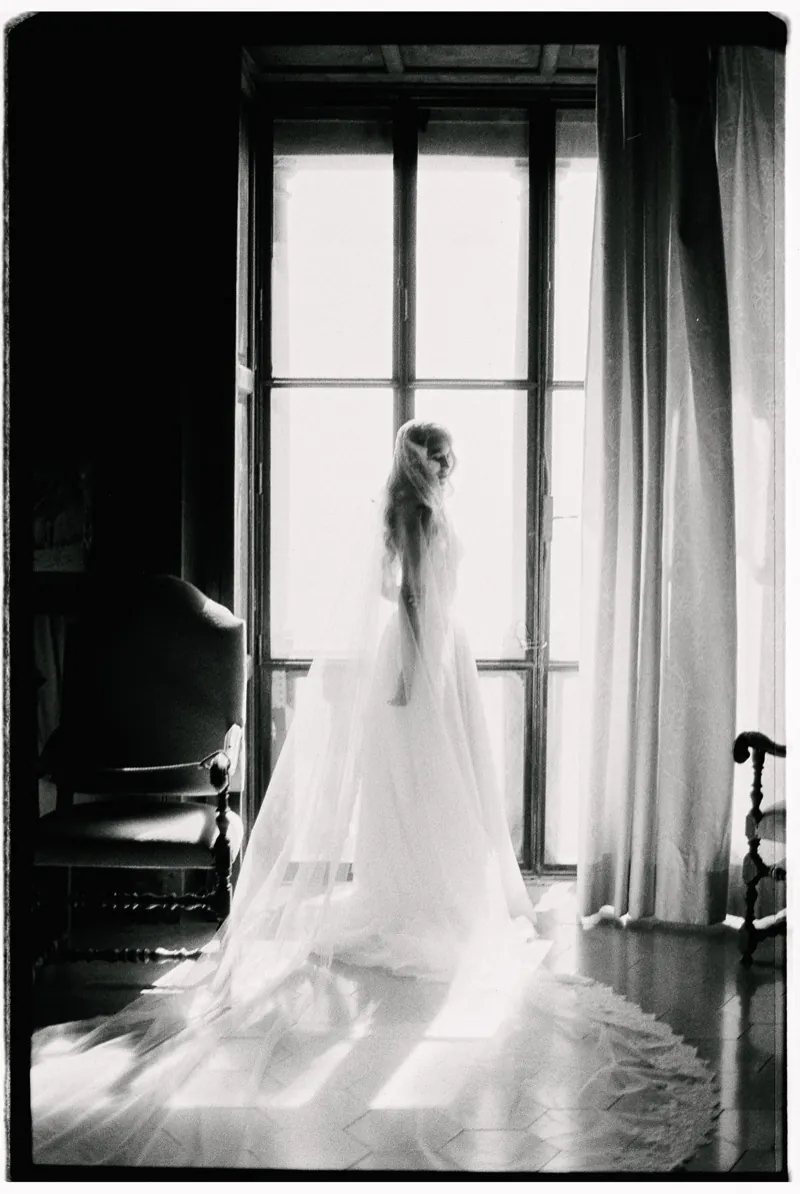 The bride at the tall window, her veil spread across the floor, shot on 35mm film, Son Marroig, Deià, Mallorca