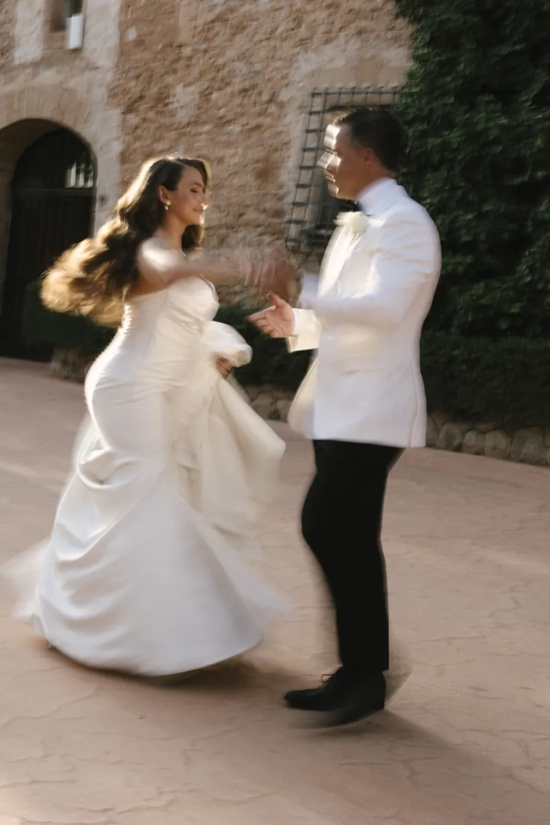 Bride and groom mid-spin as they dance in the stone courtyard, Son Termes, Mallorca